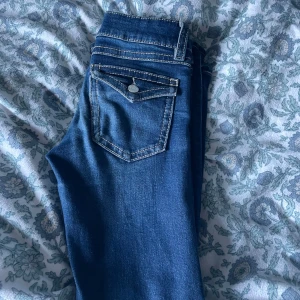 Blå jeans i bra skick - Säljer ett par snygga blå jeans i bra skick. De har en klassisk femficksdesign med snygga sömmar och en knappgylf. Perfekta för vardagsbruk och kan matchas med nästan vad som helst. Passformen är normal och de är tillverkade i ett bekvämt denimtyg. Från Gina Young!⭐️