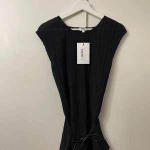 Svart plisserad top från Twist & Tango med läderband i midjan - Aldrig använd.