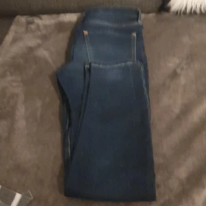 Mörkblå jeans - Säljer ett par snygga mörkblå jeans i bra skick. De har en klassisk femficksdesign och är perfekta för både vardag och fest. Jeansen har en normal passform och är tillverkade i ett slitstarkt denimtyg. 