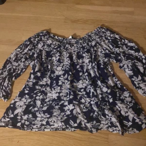 Blommig blus i blått och vitt - Säljer en söt blommig blus i blått och vitt från Cubus. Blusen har en luftig passform med trekvartsärmar och en elastisk halsringning. Perfekt för vår och sommar! 🌸