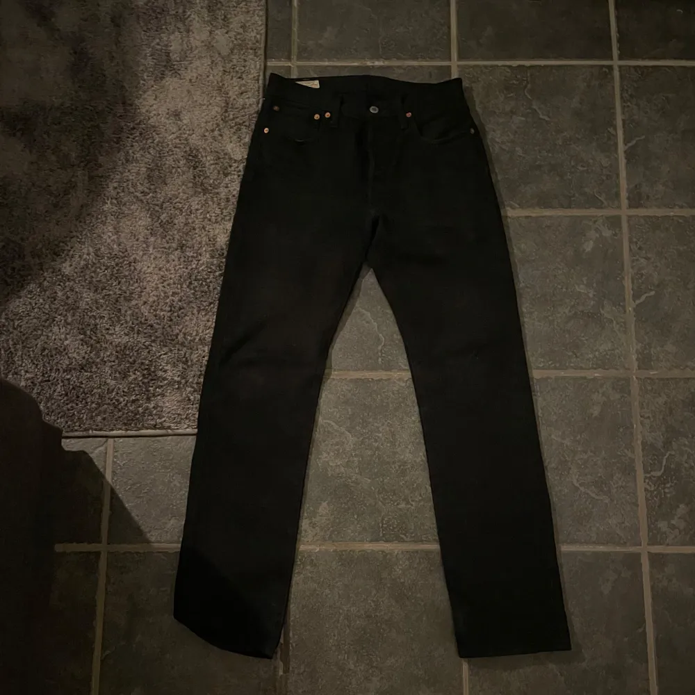 Säljer ett par klassiska svarta Levi's jeans i storlek 28x32. De är i mycket bra skick och har en snygg straight passform. Perfekta för både vardag och fest! 🖤. Jeans & Byxor.