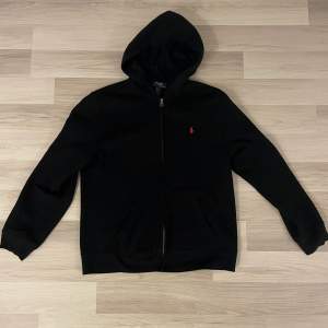 Säljer denna snygga svarta Ralph Lauren zip hoodien. Hoodien är i mycket bra skick och har inga defekter. Storleken är XL/18-20 på kidsbrandstore men passar som S. Nypris 1200kr