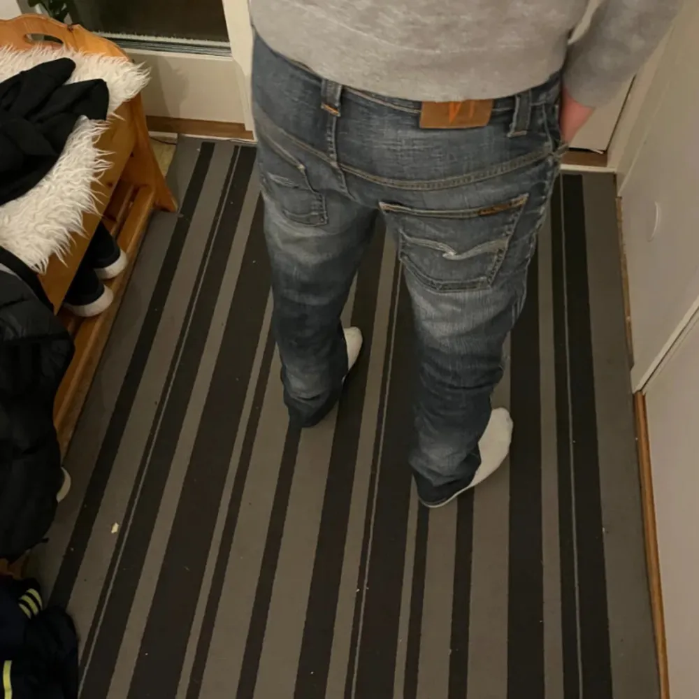 Säljer ett par mörkblå jeans från Nudie  i mycket bra skick, med snygga slitningar på framsidan.  Ny priset ligger på 1800kr vårt pris 599kr! Modellen på bilden är 180cm . Jeans & Byxor.