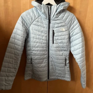 Ljusblå lättfodrad jacka från The North Face - Säljer en superfin ljusblå jacka med svarta detaljer från The North Face. Jackan har en praktisk dragkedja och flera fickor för förvaring. Den är i bra skick och redo för nya äventyr! 💙