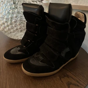 Äkta Isabel Marant sneakers  - Säljer ett par svarta sneakers från Isabel Marant i bra skick. De har en cool design med kardborreband och en beige sula. Perfekta för en avslappnad men stilren look. Passar till både vardag och fest!