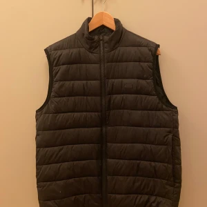 Svart quiltad väst från Barbour - Säljer en snygg svart quiltad väst från Barbour. Den har en dragkedja framtill och är perfekt för höst och vår. Västen är i mycket bra skick och passar både till vardags och lite finare tillfällen. Nypris är nästan 2000. Bara att skriva vid minsta fråga eller för fler bilder!!