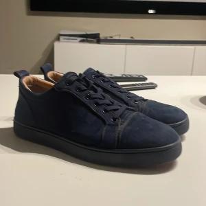 Mörkblå Loubitins med röd sula - Säljer ett par snygga mörkblåa Loubs i storlek 42 men skulle nog säga att de passar mer 42,5 till 43. Skorna har använts men har försökt mitt bästa för att hålla dem i ”skick”.                                                              Det ändå dåliga med dem är att det finns en liten trasig sömma som du ser i bild 3 men går hur lätt som helst att fixa. Pris är ej hugget i sten 