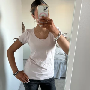 Burberry Ljusrosa t-shirt - Säljer en söt Burberry ljusrosa t-shirt i bomull. Den har korta ärmar med en fin knytdetalj på sidan. Perfekt för sommardagar eller en avslappnad vårlook. Passar bra till jeans eller kjol! Size M men passar XS och S