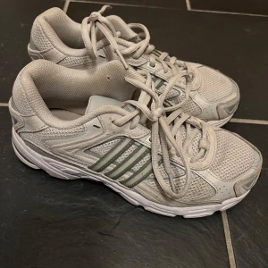 Vita/beiga/silvriga sneakers från Adidas - Säljer mina sneakers från Adidas i storlek 38, nypris 1300kr. Super sköna och passar till allt 🫶🏼