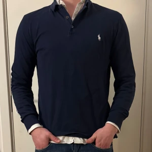 Mörkblå pikétröja från Ralph Lauren - Snygg mörkblå pikétröja från Ralph Lauren. Storleken är Small. Tveka inte på att höra av dig!