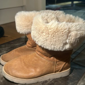 Bruna boots med pälsfoder - Säljer ett par bruna boots med mjukt beige pälsfoder. Perfekta för kalla dagar med sin varma och bekväma design. De har en rund tå och en stabil sula som ger bra grepp.