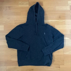 Mörkgrå hoodie - Polo Ralph Lauren - Mörkgrå raffe hoodie. Skick: 8/10, bra skick. Storlek: XS. Kontakta oss för fler bilder eller info!