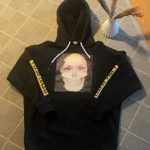 Ovanlig Svart/Gul Palm Angels Hoodie - Svart Palm Angels Hoodie som inte produceras längre och är väldigt svår att hitta. Den är väldigt sparsamt använd, men med tiden har trycket på framsidan tagit lite effekt men inget som man lägger märke till direkt.  Värt att notera är att lappen vid nacken sitter löst men jag tror nästan det ska vara så eftersom den innehåller en till design under den 😃  Storlek M herr och sitter som den ska, alltså inte oversized!  Kom gärna med bud🙏 Har du fler frågor skriv gärna ett meddelande! Tack ☺️