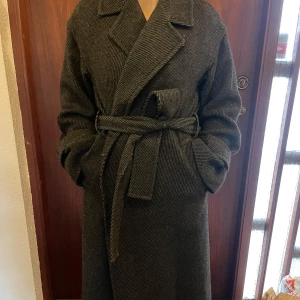 Grå melerad oversize kappa med knytbälte - Snygg grå kappa med knytbälte från MQ. Den har en klassisk design med långa ärmar. Perfekt för kyligare dagar!💕