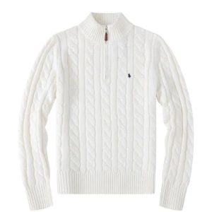 Stickad Ralph Lauren - Snygg vit stickad tröja från Ralph Lauren med kabelstickat mönster och en liten logga på bröstet. Tröjan har en dragkedja vid halsen och långa ärmar. Perfekt för kyliga dagar!