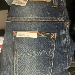 Blå jeans från Nudie Jeans w 29/ L30 - Snygga blå jeans från Nudie Jeans i 100% ekologisk bomull. De har en klassisk femficksdesign och en snygg tvättad look. Perfekta för en avslappnad stil.
