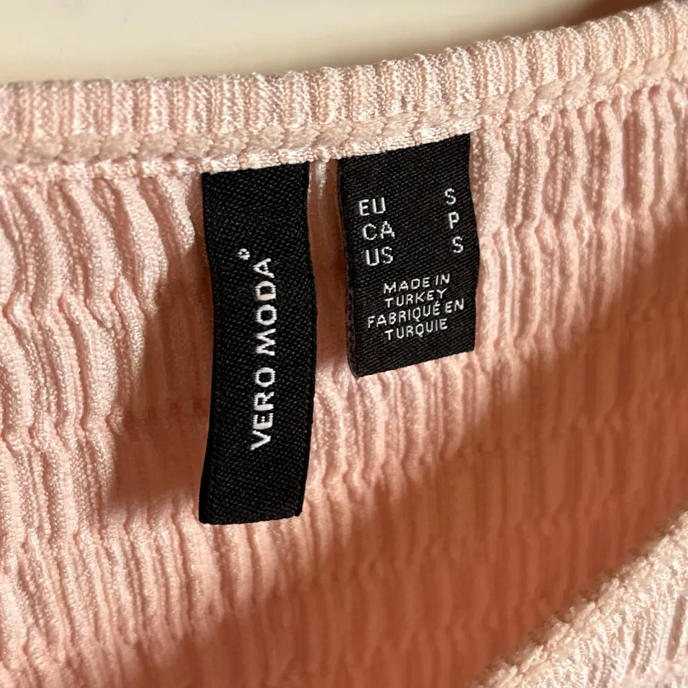 Säljer en söt ljusrosa topp från Vero Moda. Den har en ribbad struktur och korta ärmar, perfekt för en avslappnad stil. Toppen är croppad. Skriv för fler bilder eller funderingar💕. Yläosat.