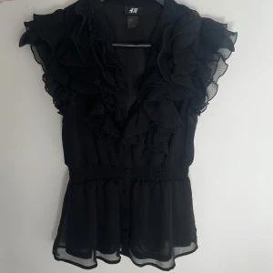 Svart h&m volang blus - Jättefin volang blus köpt på Vinted men kommer inte till användning längre💞💞🥰 