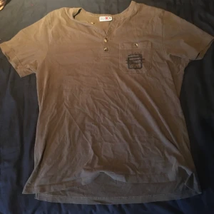 T-shirt  - T-shirt köpt på loppis men aldrig använd av mig och i bra skick. Den ser brun ut på kamera men är grön egentligen. Fråga om du har frågor!
