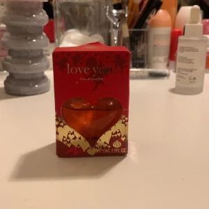 Love You! Eau de Parfum - Säljer en söt och romantisk parfym i en hjärtformad flaska. Flaskan är genomskinlig med en röd hjärtformad kork och innehåller en orange doftvätska. Perfekt present till någon du tycker om eller för att skämma bort dig själv. Flaskan rymmer 45 ml.
