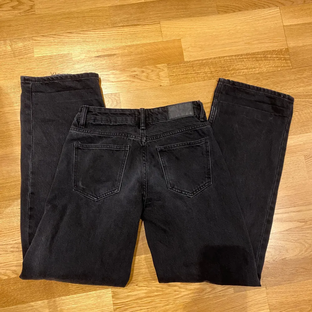 Low waist jeans och linjerna från att ha vikt byxorna syns fortfarande, jeansen har dessutom slitningar längst ned. Har bra passform. Urtvättad svart färg har byxorna.  Midjemått tvärs över: Ca 32cm Innerbenslängd: Ca 77cm. Jeans & Byxor.