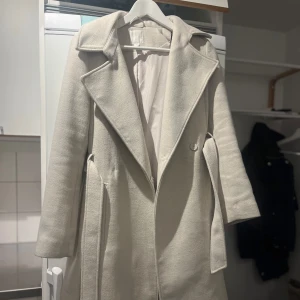 Vit kappa - Vit lång kappa från H&M. Använd något år och sedan har den bara varit i garderoben! 