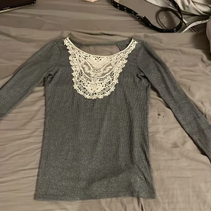 Grå tröja med spets - Grå tröja med spets i bra skick och andvänd typ fem gånger. Vet ej när den är köpt men fick den för inte jättelänge sedan.