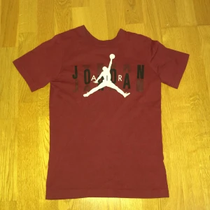 Jordan tröja - Snygg vinröd t-shirt jag säljer den eftersom den blivit lite liten. Den är i fantastisk skick förutom att det finns en liten fläck på baksidan, men märks knappt.