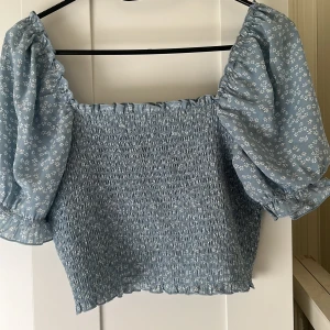 Blommig topp - En blå blommig topp, sparsamt använd!! Katt finns i hemmet!