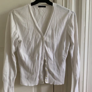 Vit kofta - Säljer denna söta, vita koftan. Det är en liten fläck på ena ärmen där nere (se bild), men verkligen inget man tänker på alls. Annars bra skick! Skriv om bilder o frågor💞