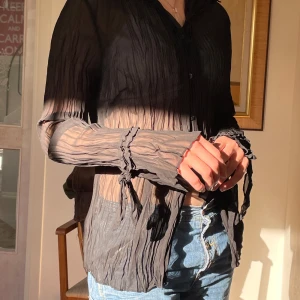 Svart skjorta genomskinlig - Svart skjorta med häftiga ärmar. Lätt genomskinlig. 