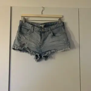 Säljer ett par ljusa jeansshorts med coola slitningar och fransiga kanter. Perfekta för sommaren och ger en avslappnad look. De har en knapp och dragkedja framtill samt klassiska fem fickor. Superbekväma och stiliga för alla sommaräventyr! 🫧💕