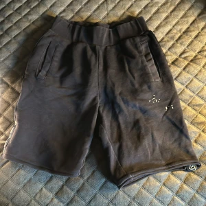 Marinblå shorts från Gant - Snygga svarta shorts från Gant med elastisk midja och sidofickor. Shortsen har en cool logotyp längs sidorna som ger en sportig look. Perfekta för en avslappnad stil.