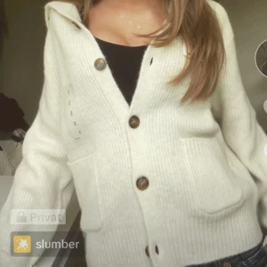 Vit ribbad kofta med knappar - Mysig vit kofta med ribbad struktur och stora knappar framtill. En stilren och bekväm tröja för alla tillfällen. Den är vit egentligen, skriv om frågor eller mer bilder.