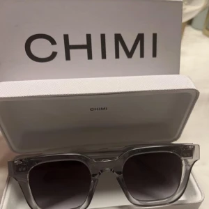 Transparenta solglasögon från Chimi 04 - Snygga transparenta solglasögon från Chimi med fyrkantig form (04) De har mörka linser och en stilren design. Perfekta för en trendig look. Använda ett par gånger bara. Box medföljer. 