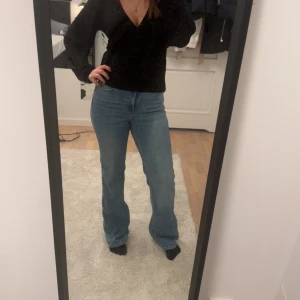 Blå jeans med bootcut från zara - Snygga blå jeans med bootcut-stil och hög midja. Perfekta för en avslappnad look. De har en klassisk design med fem fickor och en dragkedja framtill.