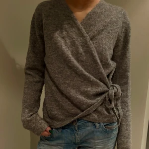 Grå omlottkofta - Mysig grå omlottkofta med knytband i midjan. Perfekt för kyliga dagar och ger en stilren look. Långärmad och tillverkad i ett mjukt material. Tröjan är i storleken S/M💘