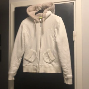 Vit jacka med teddyfoder från Adidas - Säljer en vit jacka från Adidas med mysigt teddyfoder och huva. Jackan har dragkedja och två fickor framtill. Perfekt för kyliga dagar. Storlek 38 men liten i storleken så mer 34/36.