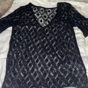 Svart spetsblus från Vero Moda - Elegant svart spetsblus från Vero Moda med v-ringning och blommigt mönster. Använd en gång, sitter super fint.
