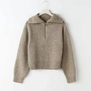 Beige stickad tröja med dragkedja - Säljer en mysig beige stickad tröja med dragkedja och hög krage. Perfekt för kyliga dagar med sin varma och bekväma design. Tröjan har långa ärmar och en ribbad struktur som ger en stilren look.