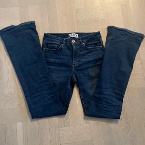 Mörkblå jeans från ONLY - Snygga mörkblå bootcut jeans från ONLY. Lite slitna nertill(kolla bild 1) men inget som syns när de sitter på. Midjemått är ca 33 cm rakt över och innebenslängd är ca 78 cm. Hör av er vid frågor