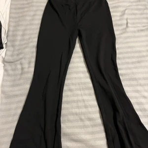 Svarta bootcut byxor - Snygga svarta bootcut byxor med hög midja. Perfekta för en stilren look. Byxorna har en skön passform och är tillverkade i ett mjukt material. De kommer ifrån Kappahl, storlek 158