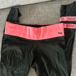 Svarta leggings från PINK - Snygga svarta leggings från PINK med en bred rosa resår i midjan och PINK-logga. Perfekta för en avslappnad stil eller träning.
