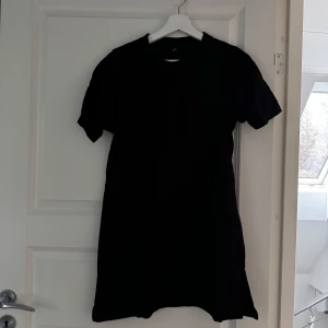 Svart klänning från Gina Tricot - Snygg svart klänning från Gina Tricot i storlek S. Den har en enkel design med korta ärmar och en rak passform. Perfekt för en stilren look.