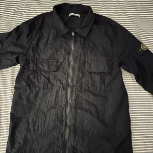 Stone Island Overshirt - svart Stone Island jacka i nylon med dragkedja och två bröstfickor. Perfekt till våren som är här om 2 månader. Priset går att diskutera.
