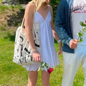 Vit ärmlös klänning - Söt vit klänning med v-ringning och smala axelband som går att justera i ryggen. Perfekt till sommaren eller som studentklänning!