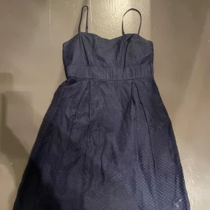 Mörkblå klänning från Stockh LM - Snygg mörkblå klänning från Stockh LM med smala axelband och diskret prickigt mönster. Perfekt för en stilren look. Klänningen har en markerad midja och är knälång. Litet slitage, se bild tre💗