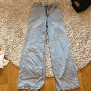Ljusblå jeans från Lindex - Säljer ett par ljusblå jeans från Lindex i storlek 152. Byxorna är lite baggy och är tillverkade i denim. De har en rak och vid passform som ger en avslappnad stil. De har en liten fläck