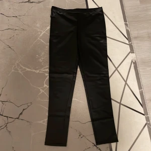Svarta leggings - Snygga svarta leggings med en tight passform. Perfekta för en stilren look och kan enkelt matchas med olika toppar. De är bekväma och mångsidiga, idealiska för både vardag och träning.