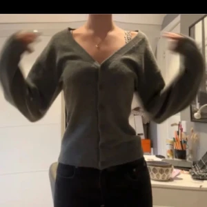 Grå kofta från Lindex - Säljer en stilren grå kofta från Lindex med v-ringning och knappar framtill. Lite figursydd med större ärmar och passar till många olika outfits. Storlek S och jag säljer den för 260kr💕